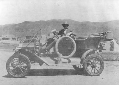 John Dunn in front of Taos Pueblo in his first touring car, 1908